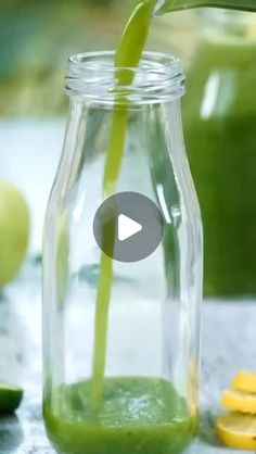 a green smoothie in a glass jar with a straw sticking out of the top