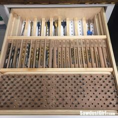 the drawer is filled with different types of screwdrivers and drillers in it