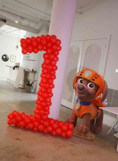 the balloon dog is standing next to the letter i