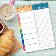 a wooden cutting board topped with croissants next to a cup of coffee