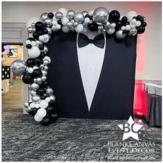 a tuxedo and bow tie balloon arch for a formal event with black, white and silver balloons