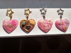 five heart shaped keychains with different designs on them sitting in a display case