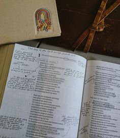 an open book sitting on top of a wooden table next to a piece of paper