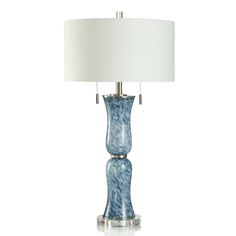 a blue glass table lamp with a white shade