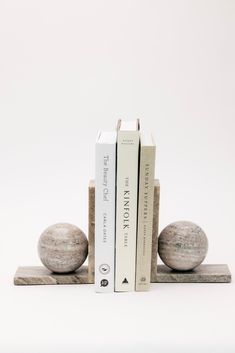 two bookends made out of stone with books on each side and one in the middle