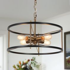 a chandelier with three lights hanging from it's center ring in a dining room