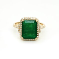 an emerald and diamond ring on a white background