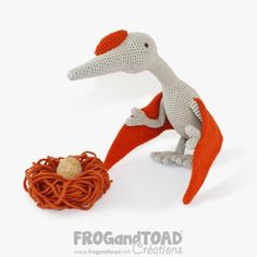 an orange and gray knitted bird with a nest