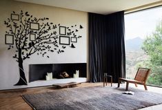 a living room with a large tree on the wall and pictures hanging on the wall