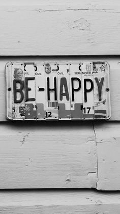 a license plate that says be happy on it's side wall, with the words be happy written in black and white