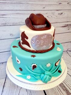 a three tiered cake with cowboy hats on it's top and bottom layer