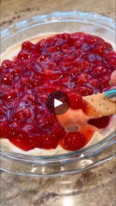 someone is dipping some fruit into a bowl with crackers in it on the counter