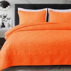 an orange bedspread and pillows in a bedroom