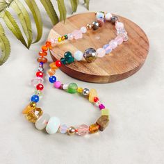 🎉 Step into a world of color and fun with our vibrant 17 inch necklace, a playful and eclectic mix of various gemstones, glass, wood, plastic, and ceramic beads. This handknotted necklace is perfect for those who love bold, unique, and artisanal jewelry. 🔹 Diverse Confetti Bead Mix: Our necklace showcases an exciting array of beads, each chosen for its unique shape, size, and material. Ranging from 4-12mm, the beads come together to create a lively confetti effect. The blend of bright and colorful beads results in a truly fun and eye-catching piece. 🔹 Vibrant Handknotted Design: Each bead is meticulously handknotted on a neon orange nylon cord, providing a strong and vivid backdrop that accentuates the necklace's playful charm. This knotting technique not only adds to the necklace's dur Rainbow Beaded Necklaces With Wooden Beads As Gift, Adjustable Rainbow Beaded Necklaces With Wooden Beads, Adjustable Rainbow Beaded Necklace With Wooden Beads, Adjustable Multicolor Eclectic Necklace, Playful Multicolor Beaded Necklaces For Jewelry Making, Eclectic Beaded Necklaces As Gift, Eclectic Colorful Beaded Necklaces For Gifts, Adjustable Multicolor Whimsical Beaded Necklaces, Whimsical Adjustable Multicolor Beaded Necklaces