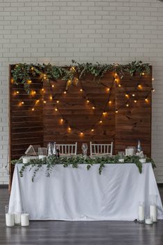 the head table is decorated with greenery and candles