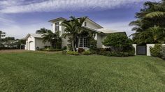 a white house with palm trees in the front yard