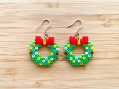 a pair of earrings made out of legos sitting on top of a wooden table