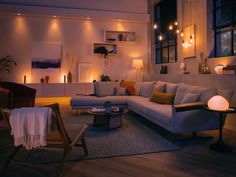 a living room filled with furniture and lights on the wall next to a couch in front of a window