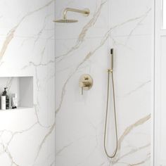 a bathroom with marble walls and flooring, including a walk in shower that has thermostaer built into the wall