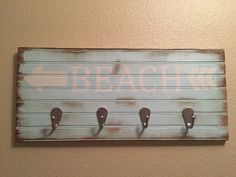 a wooden sign with hooks on it that says beach walk and arrows pointing in different directions