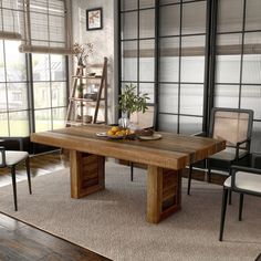 a wooden table sitting in front of two chairs next to a window with blinds on it