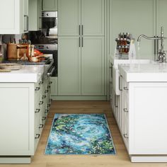 a kitchen with green cabinets and an area rug on the floor in front of it