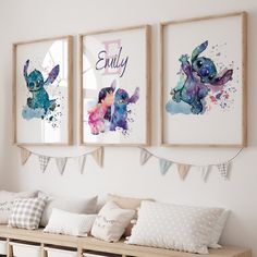 three framed pictures hang on the wall above a bench with pillows and blankets underneath them