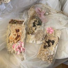 three small purses are sitting on a white cloth covered tablecloth with pink flowers and pearls