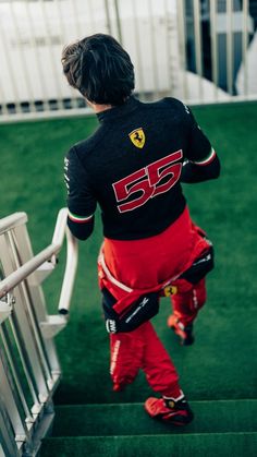 a man walking up some stairs wearing red pants and black shirt with the number 55 on it