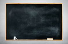 an empty blackboard in front of a gray wall