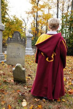 a person in a robe standing next to a grave