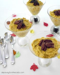 three desserts with pecans and pumpkin in them on a white tablecloth next to silverware