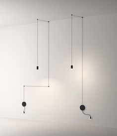 three black lights hanging from the ceiling in a room with white walls and flooring