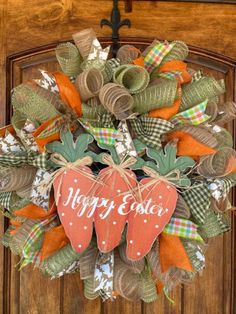 an orange and green wreath with two strawberries hanging on the front door to say happy easter