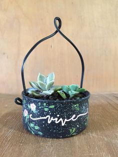 a potted plant sitting on top of a wooden table next to a metal holder