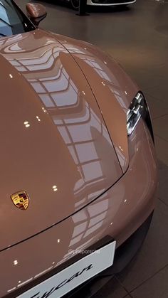 a brown sports car parked in a showroom