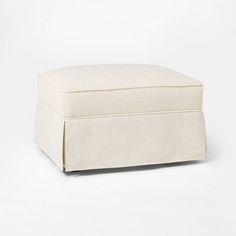 a small white ottoman sitting on top of a white floor