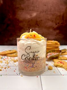 a glass jar filled with cookies and sprinkles on top of a table