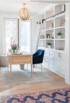 a living room with white walls and wooden floors, a ladder to the ceiling, blue chairs