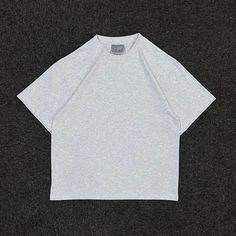 a white t - shirt sitting on top of a black surface with the word,'no