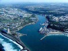 an aerial view of a city and the ocean with buildings on both sides that are surrounded by water