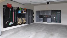 an empty garage with several storage cabinets and tools hanging on the wall in front of it