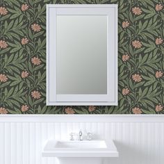 a bathroom sink sitting under a mirror next to a wall mounted faucet with flowers on it