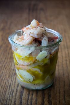 a glass jar filled with food on top of a wooden table