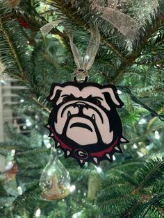 a christmas ornament hanging from the top of a tree with an image of a bulldog on it