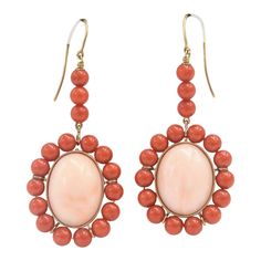 This is part of Chairish’s Fine Jewelry assortment.  These earrings feature a large oval cabochon angel skin coral piece measuring approximately  .80" x .60" set in a frame of orange coral beads measuring approximately 5.5 mm each.  The earrings dangle off an 18k yellow gold wire.  Pierced ears are required to wear these. Drop Gold Earrings, Angel Skin, Pink Angel, Orange Coral, Coral And Gold, Coral Beads, Gold Wire, Late 20th Century, Color Collection