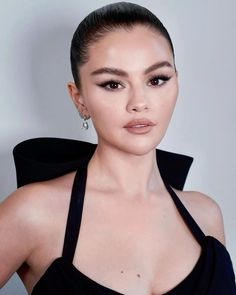 a woman in a black dress posing for the camera