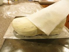 an uncooked dough sitting on top of a metal pan covered in white cloth