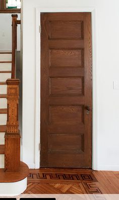 a wooden door sitting next to a stair case