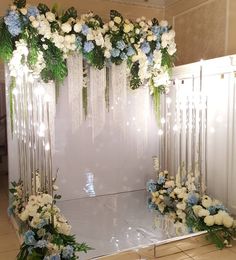 a white and blue wedding arch decorated with flowers